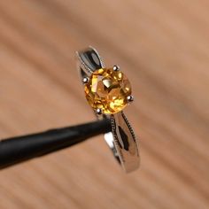 It is a natural citrine ring. The main stone is 7mm*7mm round cut, weight about 1.25 carats.The basic metal is sterling silver and plated with rhodium.To change the metal to a solid gold (white/rose) or platinum is also available, please ask for a quotation if you want.You can also go to my shop Home for more elegant rings: https://www.etsy.com/shop/godjewelry?ref=hdr_shop_menuMore citrine rings: https://www.etsy.com/shop/godjewelry?ref=seller-platform-mcnav&section_id=20715039Customization Citrine Rings With Accent Stones, Round Topaz Ring With Citrine Center Stone, Citrine Promise Rings With Round Cut, Topaz Citrine Ring With Center Stone, Citrine Birthstone Ring With Accent Stones, Yellow Topaz Crystal Ring, Classic Round Topaz Birthstone Ring, Round Diamond Cut Topaz Ring, Citrine Ring With Center Stone