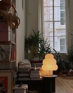 a living room filled with lots of furniture and plants on top of wooden flooring