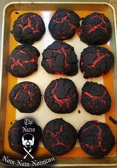 there are many black cookies with red splatters on them