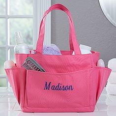 a pink tote bag with personalized items in it sitting on a white counter