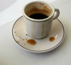 a dirty cup of coffee sitting on top of a saucer