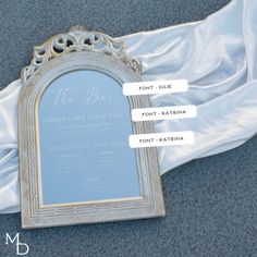 the back of a white and gold wedding dress with an ornate frame on it's side