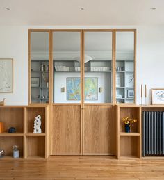 a living room with wooden floors and bookshelves on the wall next to each other