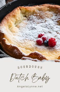 a close up of a pie in a pan with raspberries and powdered sugar on top