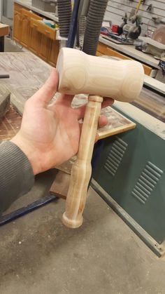 a person holding a piece of wood in their hand while working on some kind of object