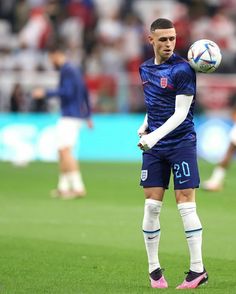 a man standing on top of a soccer field holding a soccer ball in his hand