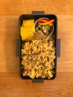 a container filled with rice and corn on the cob