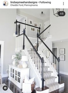 a white staircase with black railings and wood flooring