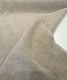 a close up view of the fabric on top of a couch with a white wall in the background