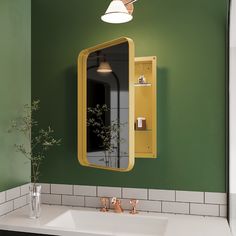 a bathroom with green walls and white tile on the floor, along with a yellow medicine cabinet