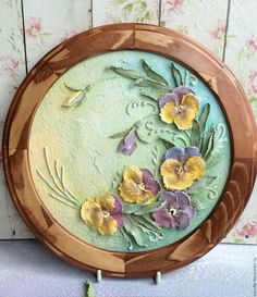 a wooden plate with flowers painted on it