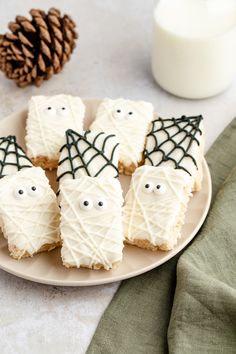 cookies decorated with white frosting and spooky eyes on a plate