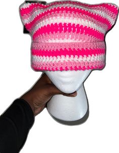 a pink and white knitted hat on top of a mannequin's head