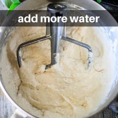 a metal bowl filled with batter on top of a wooden table