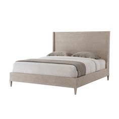 an upholstered bed with white sheets and pillows