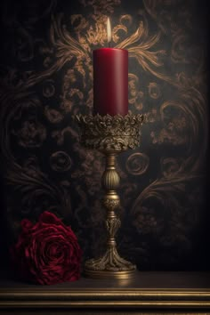 a red candle sitting on top of a metal stand next to a red rose in front of a wall