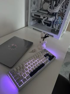 a computer keyboard and mouse sitting on a desk next to a small white rabbit figurine