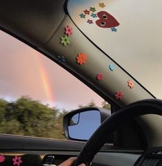 a car with stickers on the windshield and a rainbow in the sky behind it