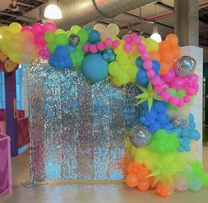 balloons and streamers are on display in an indoor space with disco balls, sequins, and other decorations