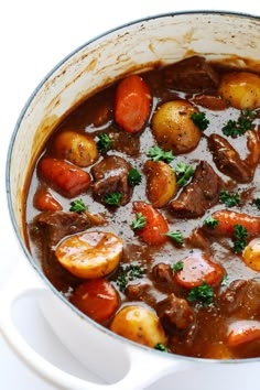 a pot filled with stew and vegetables on top of a table