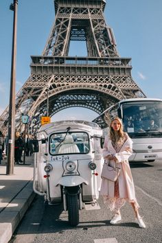 a woman standing next to a white van in front of the eiffel tower