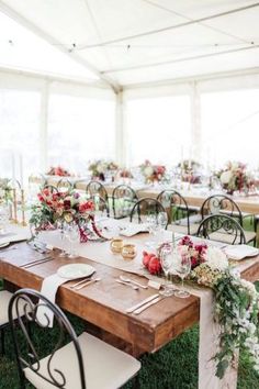 the tables are set with place settings and flowers on them for an outdoor wedding reception