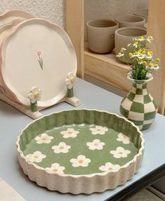 a table topped with plates and vases filled with flowers