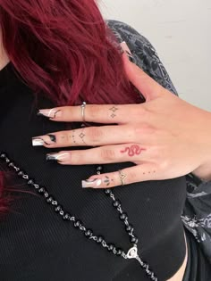 a woman with red hair and tattoos on her hands