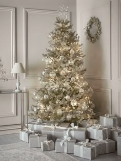 a white christmas tree with presents under it