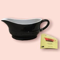 a black and white gravy pitcher with a tag on the side next to it