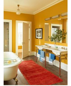 a bath room with a tub a sink and a rug on the floor in front of it