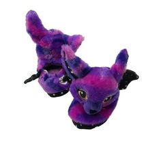 a purple and black stuffed animal laying on top of a white surface