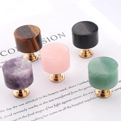 four different colored knobs sitting on top of a piece of paper next to each other