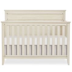 a white crib with no sheets on it, in front of a white background