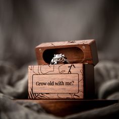 a wooden box with a ring in it that says grow old with me