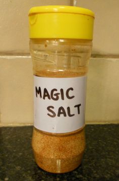 a jar filled with salt sitting on top of a counter next to a yellow lid