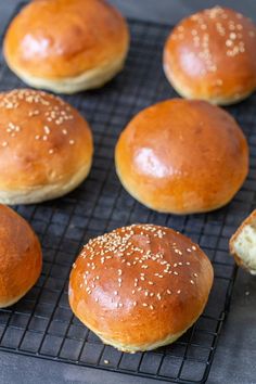 several buns on a cooling rack with sesame seeds