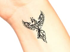 a small tattoo on the side of a woman's leg shows a bird with wings