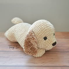 a stuffed dog laying on top of a wooden table