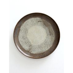 a brown and white plate with speckles on it sitting on a table top