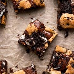 chocolate chip cookies and oreo cookie bars are arranged on top of parchment paper, ready to be eaten