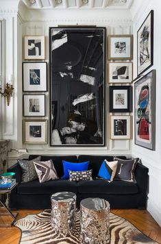 a living room filled with furniture and framed pictures on the wall above it's coffee table