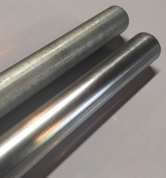 two metal tubes sitting next to each other on a table