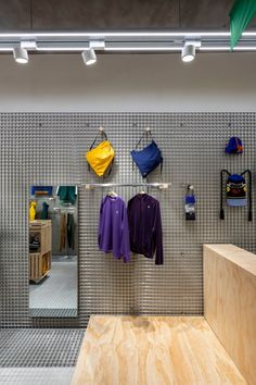 the inside of a clothing store with clothes hanging on hooks