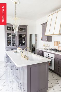 a kitchen with gray cabinets and marble counter tops, an island in the middle is surrounded by clear acrylic stools