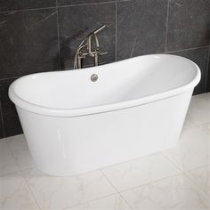 a white bath tub sitting in a bathroom next to a black tiled wall and floor