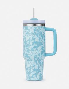 a blue and white flowered cup with a straw sticking out of it's lid