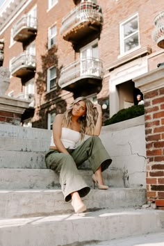 a woman sitting on steps in front of a brick building