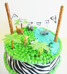 a birthday cake decorated with animals and plants