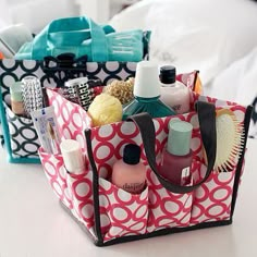 a polka dot tote bag filled with beauty products and personal care items sitting on a bed